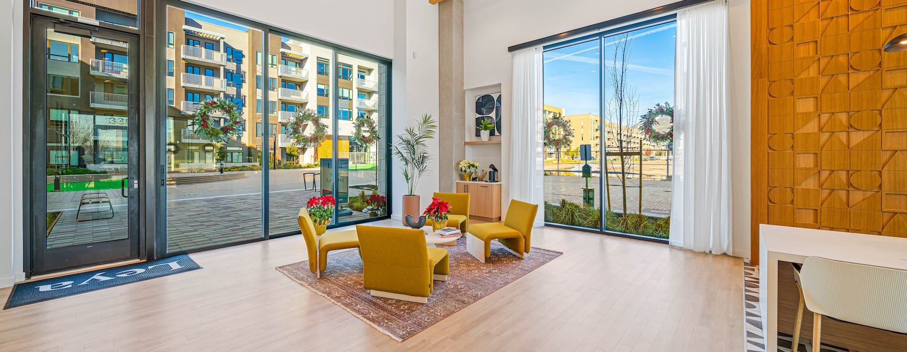 a room with a wood floor with a rug and a table and chairs