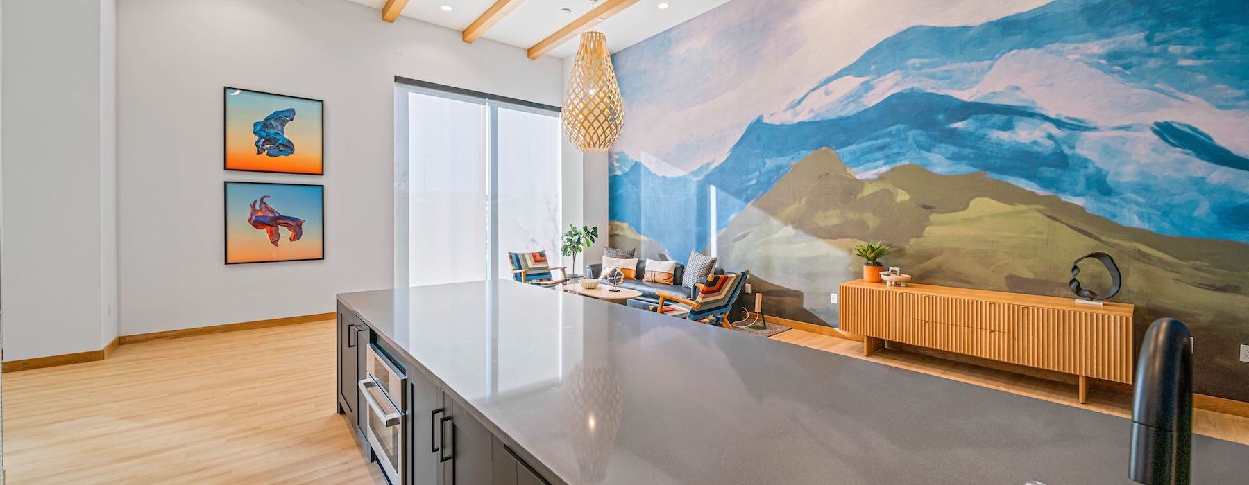 a kitchen with a large painting on the wall